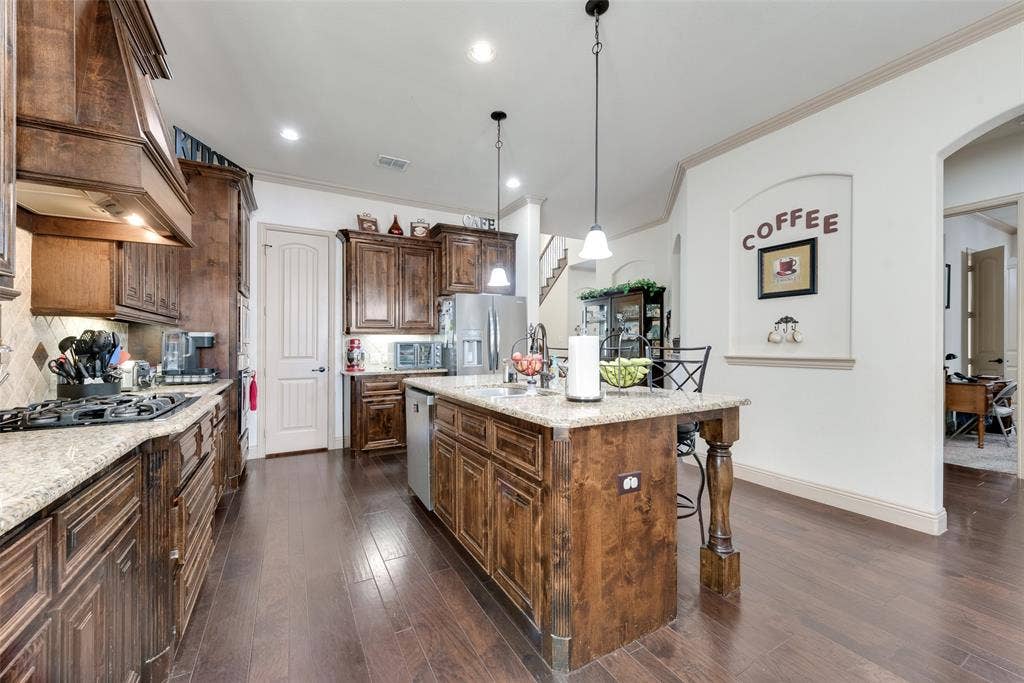5056 Empire Way, Irving, TX 75038 Kitchen with pendant lighting, light stone countertops, and custom range hood