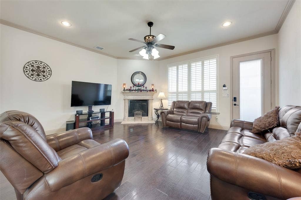 5056 Empire Way, Irving, TX 75038 Living room with a high end fireplace, ornamental molding, dark hardwood / wood-style floors, and ceiling fan