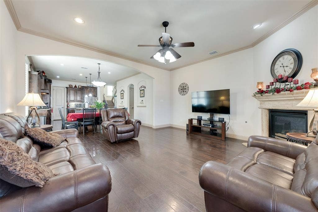 5056 Empire Way, Irving, TX 75038 Living room featuring crown molding, a fireplace, dark hardwood / wood-style floors, and ceiling fan