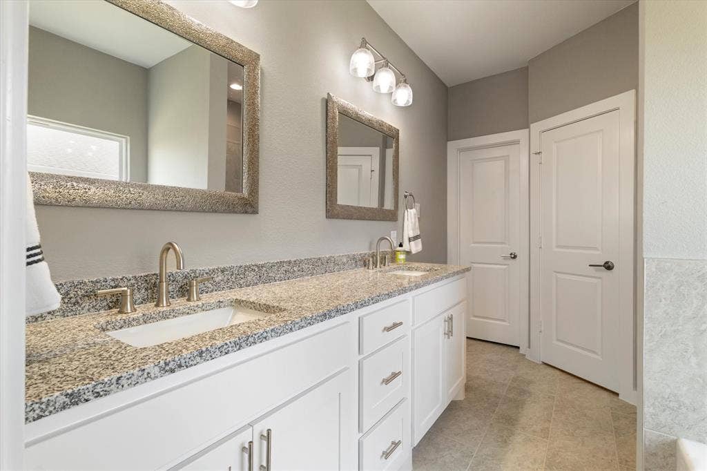Dual vanity with granite countertop, undermount sinks, and brushed nickel fixtures