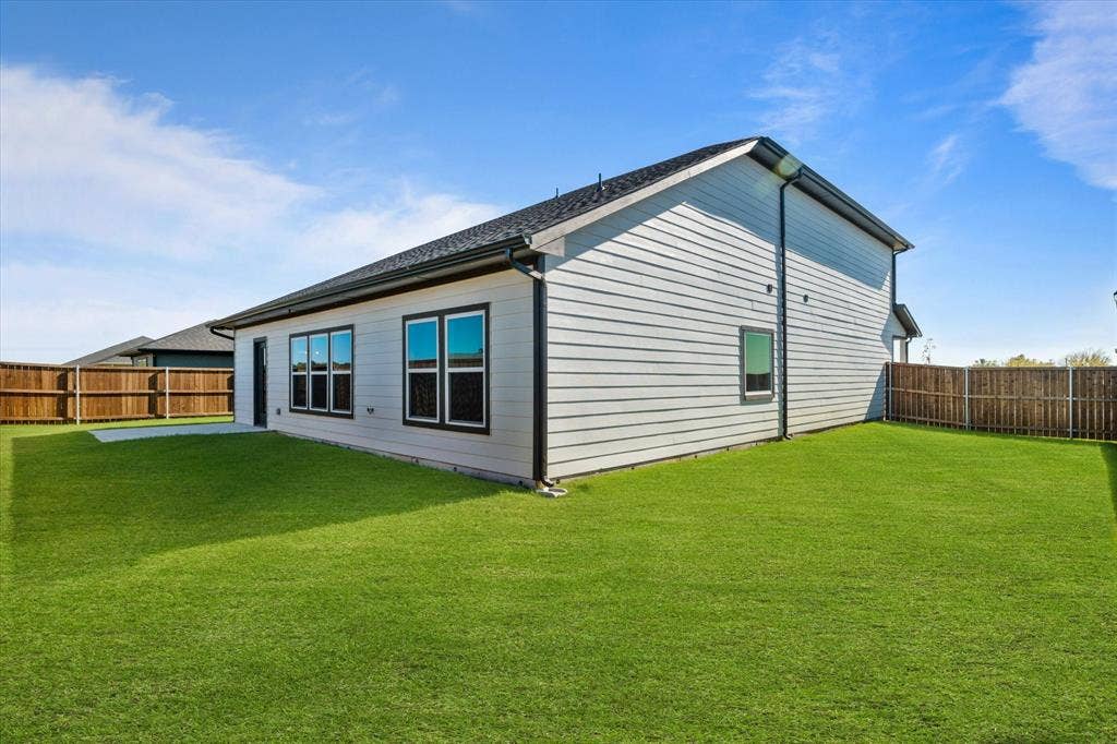 Expansive green lawn, wood fence perimeter, and a concrete patio