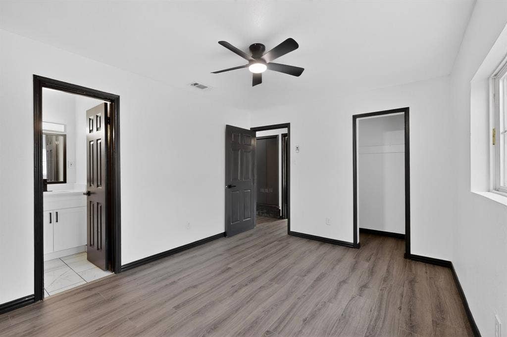 301 Stoneport Drive, Dallas, TX 75217 Wood-finish flooring, ceiling fan with integrated lighting, white walls, black trim, and a white vanity with an integrated sink