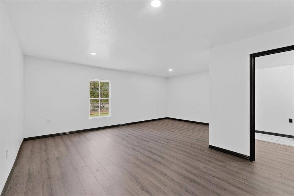 301 Stoneport Drive, Dallas, TX 75217 Recessed lighting, wood-finish flooring, white painted walls, and dark trim