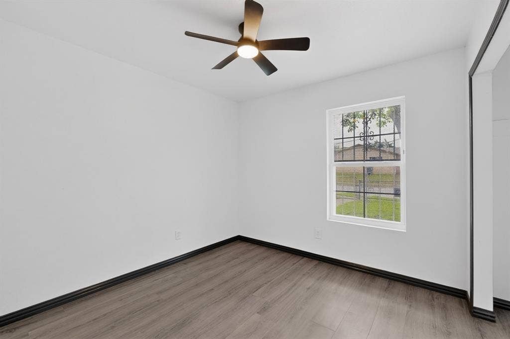 301 Stoneport Drive, Dallas, TX 75217 Wood-finish flooring, white walls, and a ceiling fan with integrated lighting