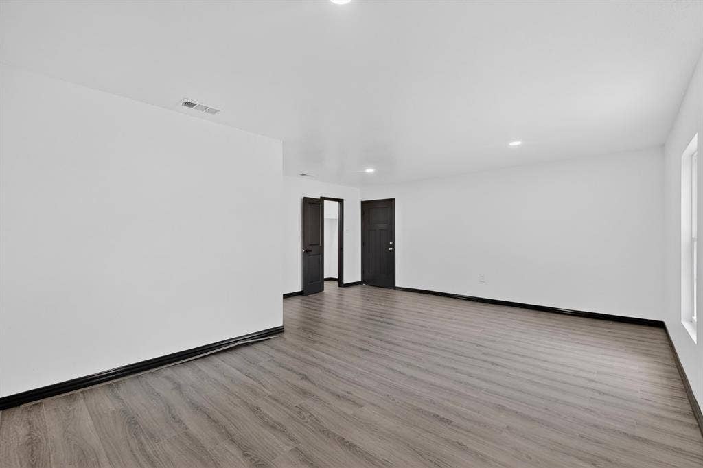 301 Stoneport Drive, Dallas, TX 75217 Spacious interior featuring wood-finish flooring, recessed lighting, white walls, and dark trim