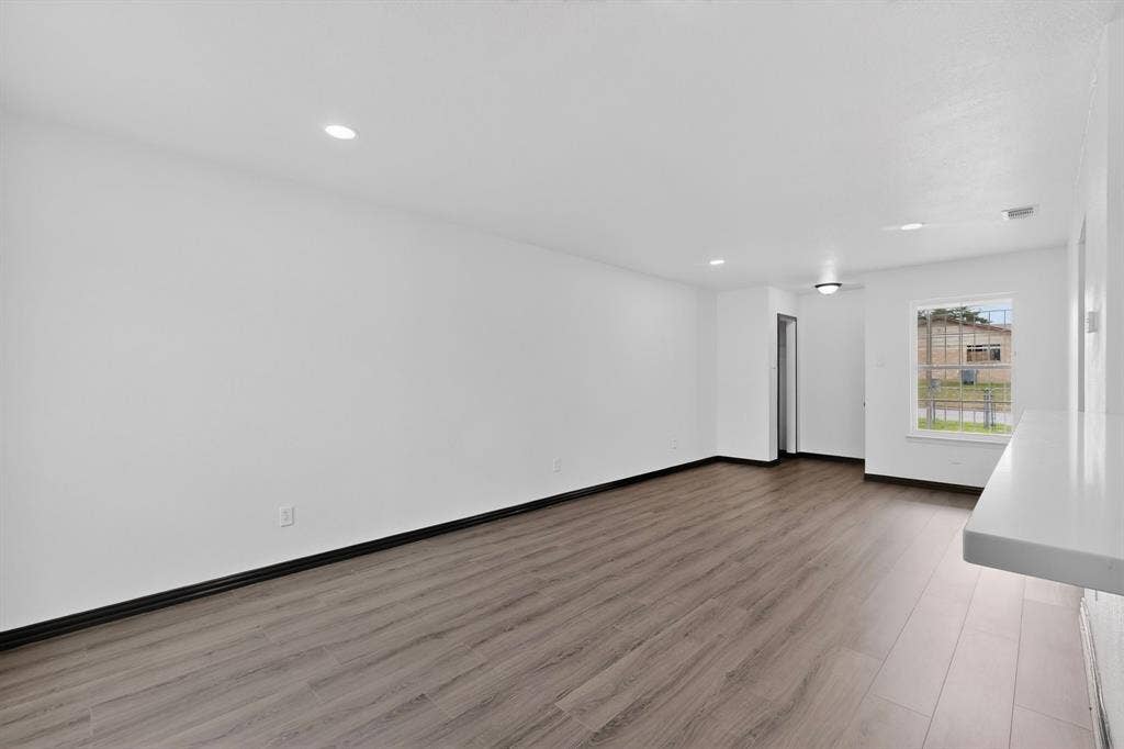 301 Stoneport Drive, Dallas, TX 75217 Spacious interior featuring wood-finish flooring, recessed lighting, and a window for natural light