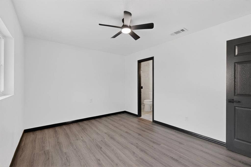 301 Stoneport Drive, Dallas, TX 75217 Wood-finish flooring, white walls, and a contemporary ceiling fan