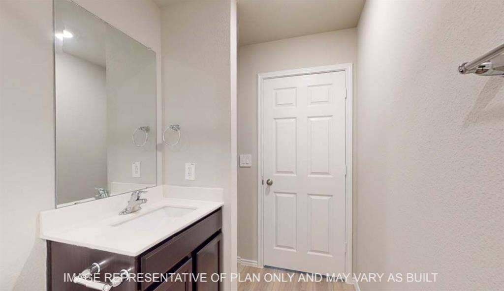 10412 Altair Drive, Waco, TX 76708 Vanity with a white countertop and integrated sink, chrome faucet, and dark wood-finish cabinetry
