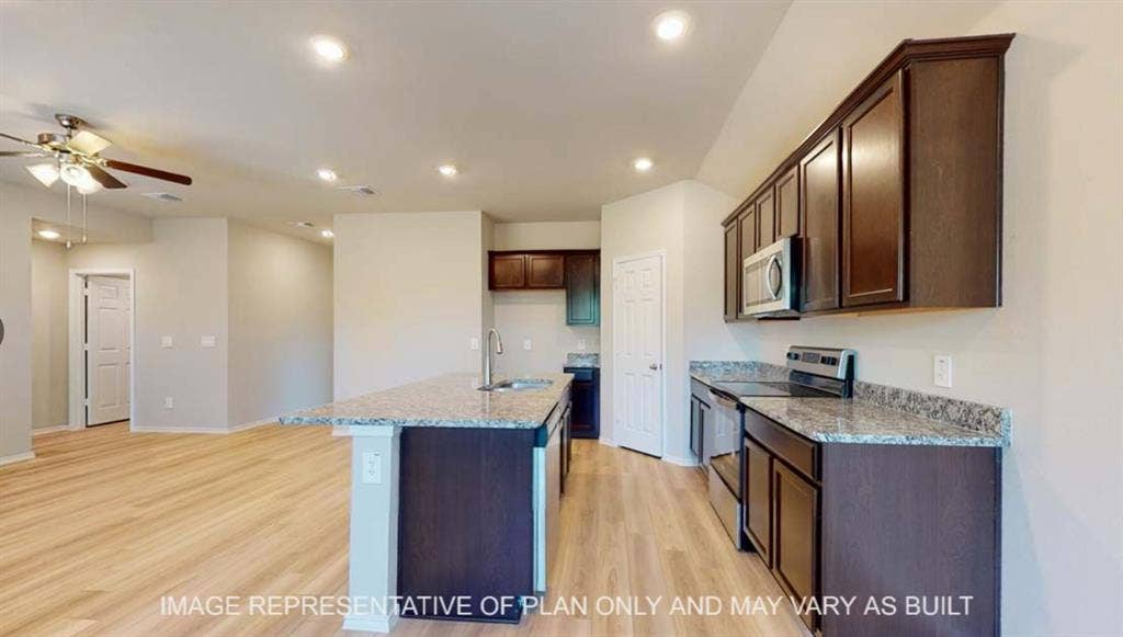 10412 Altair Drive, Waco, TX 76708 Open-concept kitchen with a central island, recessed lighting, wood-finish flooring, and dark wood cabinetry