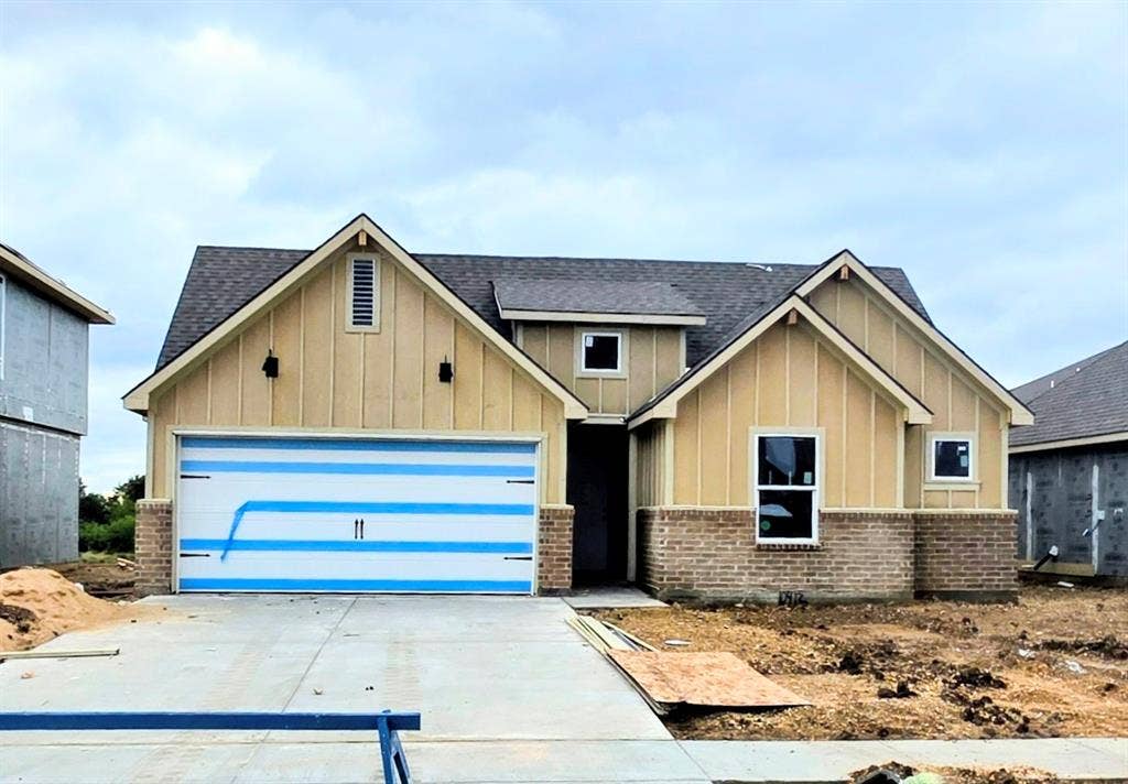 10412 Altair Drive, Waco, TX 76708 Board and batten siding with brick accents, dark-shingle roof, and a two-car garage