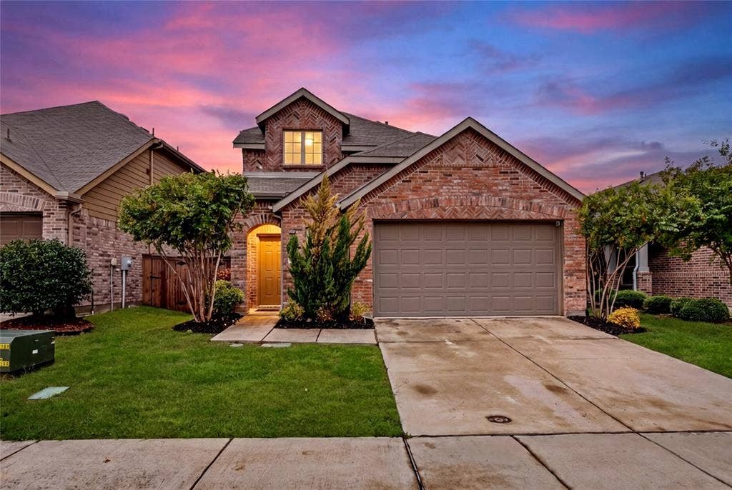 3955 Chesapeake Lane, Heartland, TX 75126 Brick facade with an arched entry, mature landscaping, and an attached garage