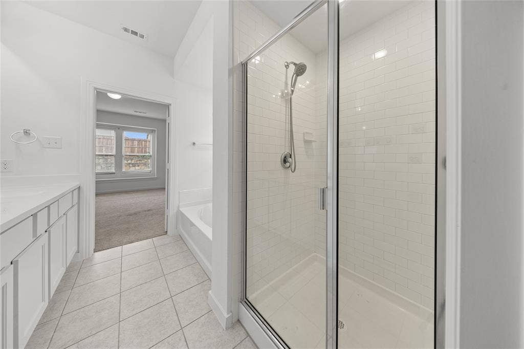 3955 Chesapeake Lane, Heartland, TX 75126 Primary Bathroom with Frameless Glass Shower Enclosure and Subway Tile SurroundSleek primary bathroom featuring a frameless glass shower enclosure with chrome hardware and polished chrome showerhead