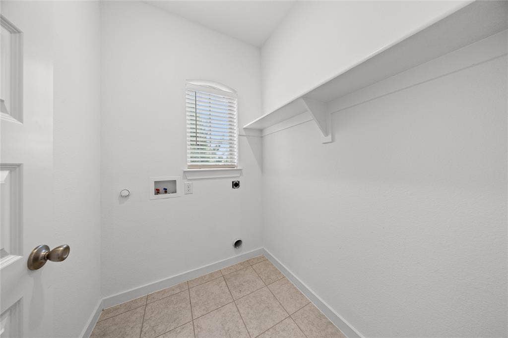 3955 Chesapeake Lane, Heartland, TX 75126 Utility room featuring tile flooring, a window with blinds, and an integrated storage shelf