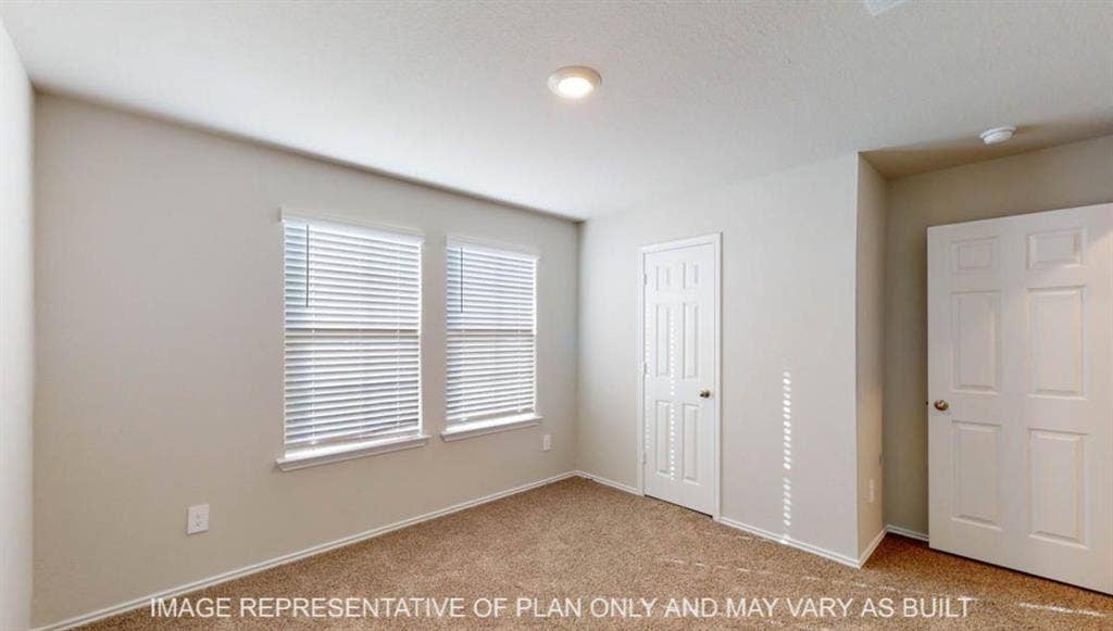 10405 Altair Drive, Waco, TX 76708 Wall-to-wall carpeting in a neutral tone, two windows with blinds, a recessed ceiling light, and two paneled doors with hardware