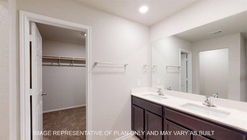 10405 Altair Drive, Waco, TX 76708 Double vanity with two integrated sinks, expansive wall-mounted mirror, and dark wood-finish cabinetry