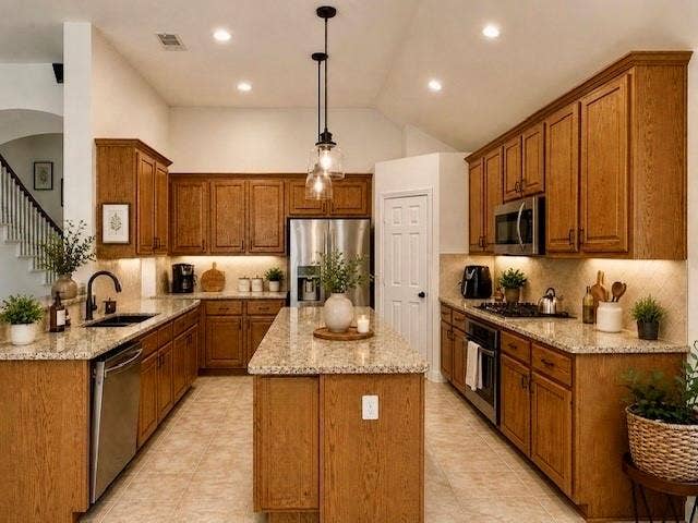 107 Appalachian Way, McKinney, TX 75071 Kitchen featuring wood-finish cabinetry, granite countertops, stainless steel appliances, and a central island