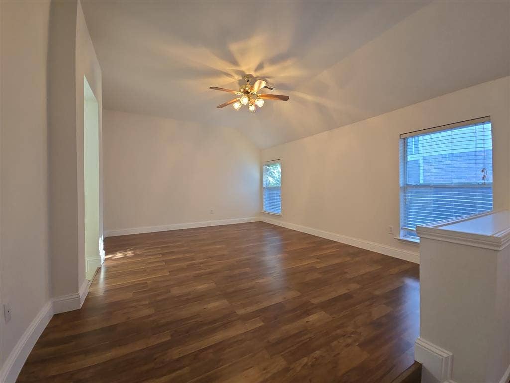 2424 Brycewood Lane, Plano, TX 75025 Vaulted ceiling with a ceiling fan light fixture, wood-finish flooring, and two windows