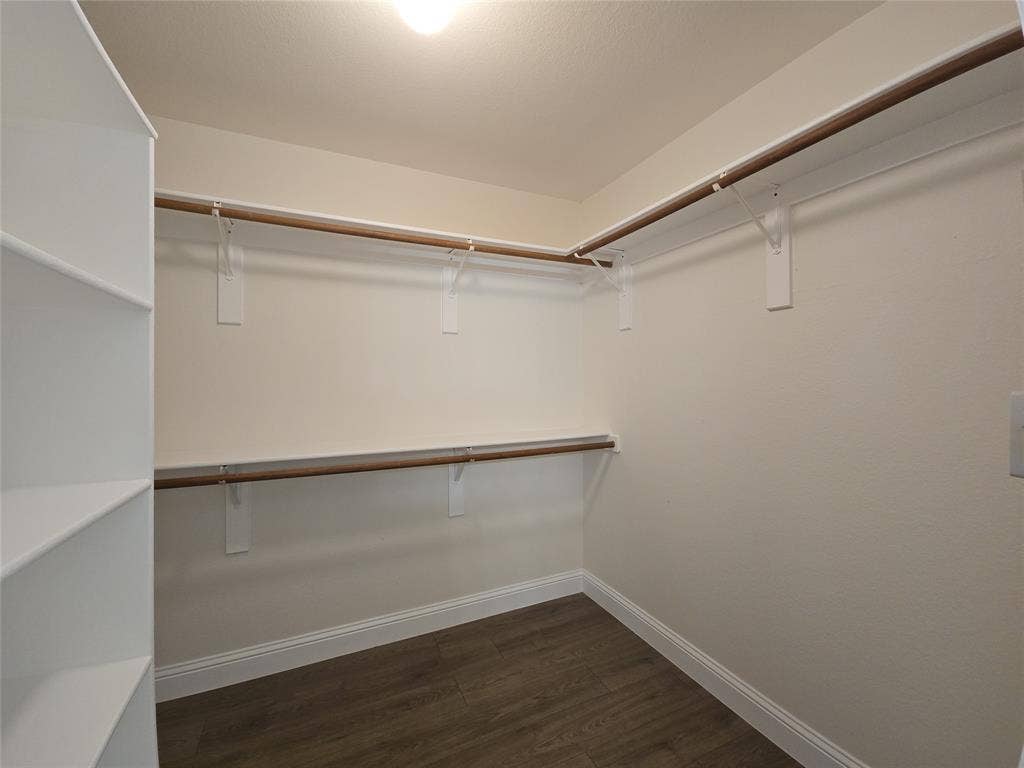2424 Brycewood Lane, Plano, TX 75025 Walk-in closet featuring wood-finish flooring, built-in shelving, and dual clothes rods