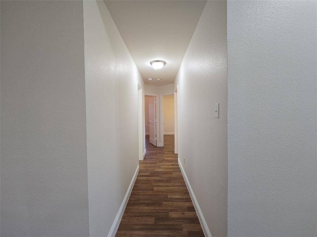 2424 Brycewood Lane, Plano, TX 75025 Hallway featuring wood-finish flooring, light neutral paint, and a ceiling-mounted light fixture