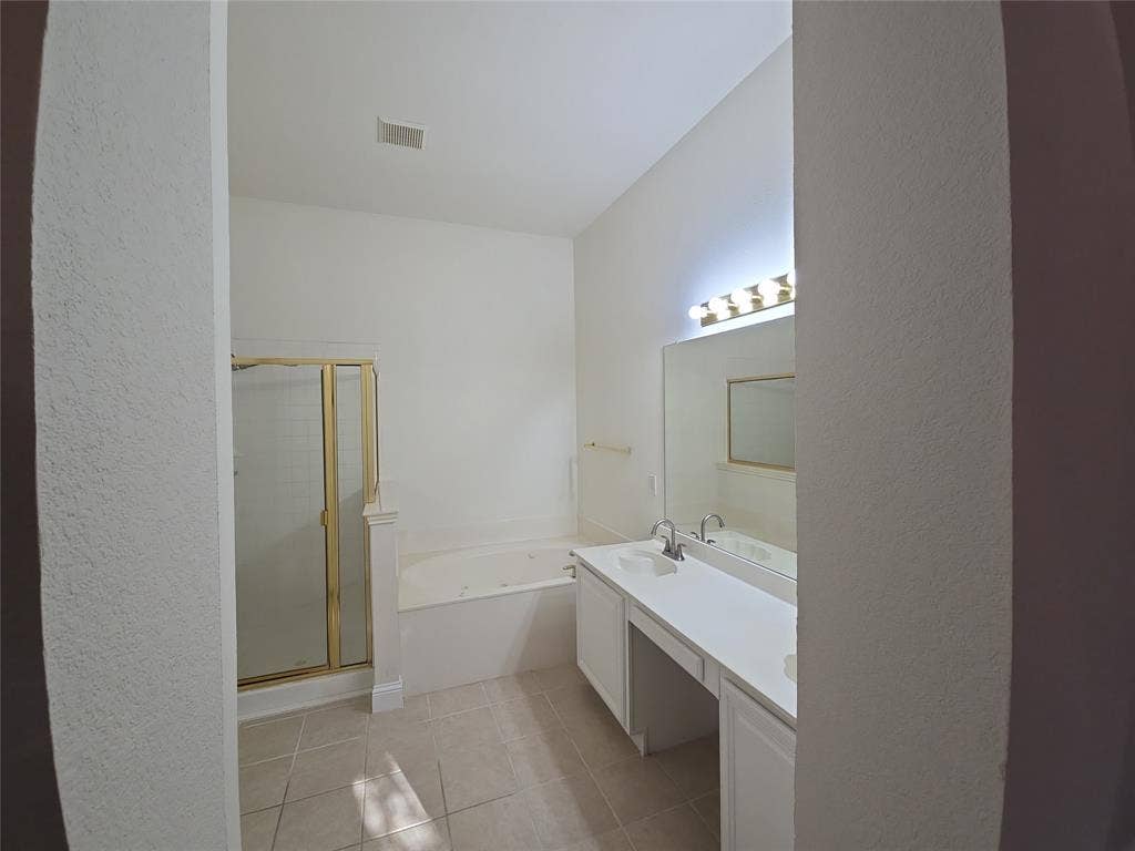 2424 Brycewood Lane, Plano, TX 75025 Dual vanity with integrated sinks, built-in soaking tub, and enclosed shower