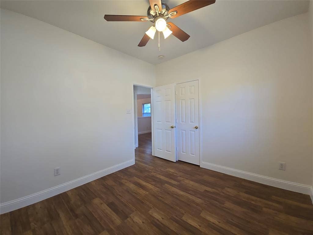 2424 Brycewood Lane, Plano, TX 75025 Wood-finish flooring, white walls, ceiling fan with integrated lighting, and white bi-fold closet doors