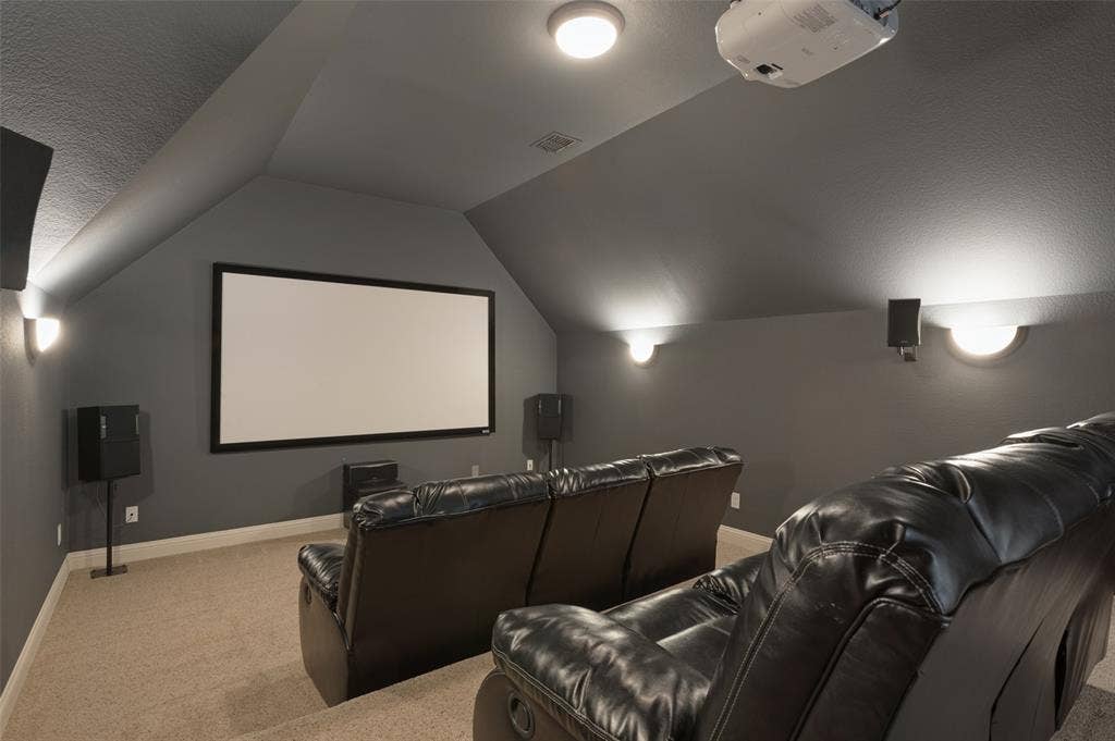1504 Daisy Lane, Flower Mound, TX 75028 Dedicated media room featuring a large projection screen, wall-mounted speakers, recessed lighting, and sconce lighting