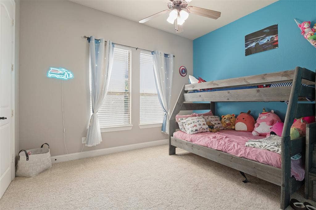 1504 Daisy Lane, Flower Mound, TX 75028 Carpeted flooring, two windows with blinds, ceiling fan with integrated lighting, two-tone wall paint