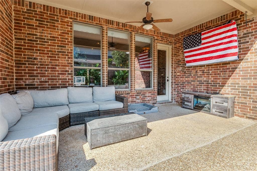 1504 Daisy Lane, Flower Mound, TX 75028 Covered patio featuring a brick exterior wall, a ceiling fan, and multiple windows