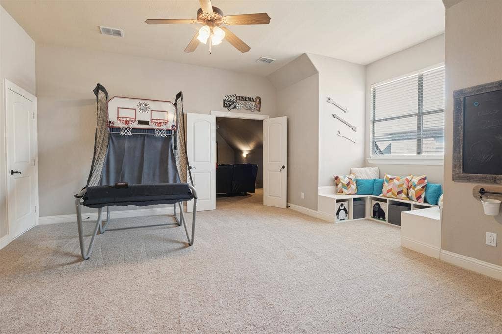 1504 Daisy Lane, Flower Mound, TX 75028 Carpeted room featuring a ceiling fan, built-in window seating with cubby storage, and a single window with blinds
