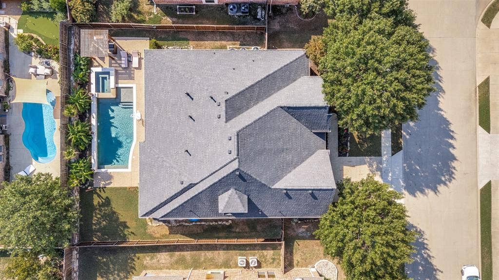 1504 Daisy Lane, Flower Mound, TX 75028 Roof with multiple gables, outdoor pool, spa, and a paved patio area