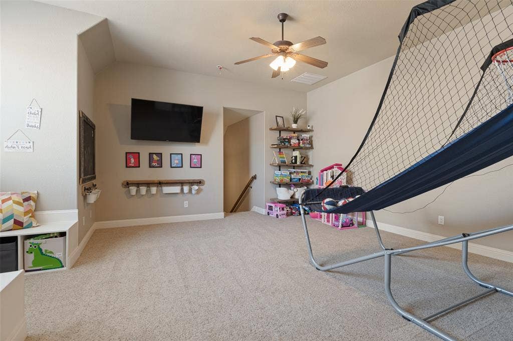 1504 Daisy Lane, Flower Mound, TX 75028 Carpeted room with a vaulted ceiling and a ceiling fan