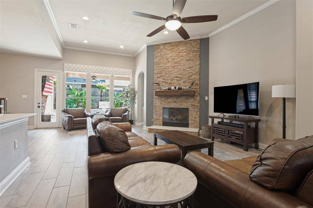 1504 Daisy Lane, Flower Mound, TX 75028 Living area featuring vaulted ceilings, a stone-clad fireplace with wood mantel, wood-finish flooring, and recessed lighting