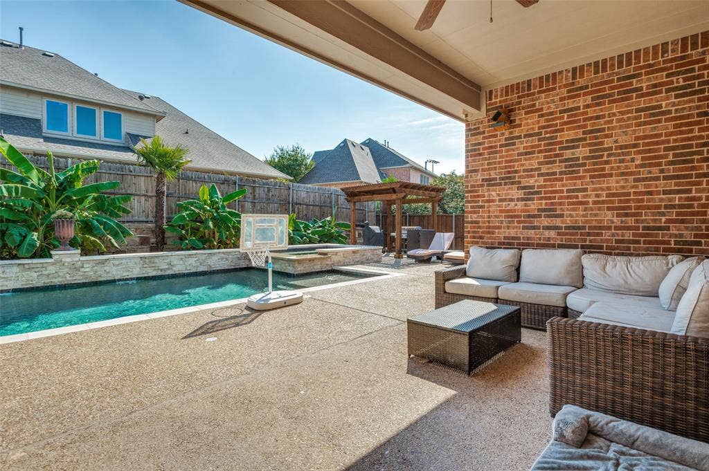 1504 Daisy Lane, Flower Mound, TX 75028 Expansive covered patio with brick exterior, ceiling fan, and concrete-finish flooring