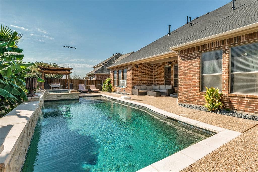 1504 Daisy Lane, Flower Mound, TX 75028 In-ground swimming pool with integrated spa and waterfall feature