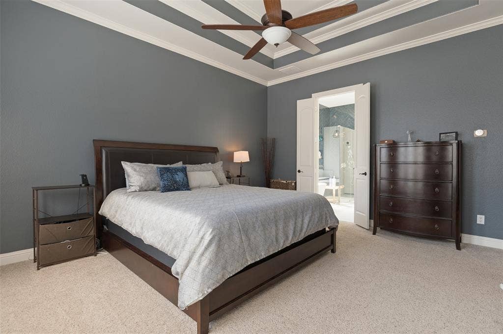 1504 Daisy Lane, Flower Mound, TX 75028 Tray ceiling with crown molding, ceiling fan, carpeting, and double doors opening to an adjoining room