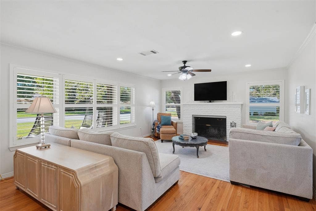 3712 Brighton Road, Fort Worth, TX 76109 Bright, spacious living room with warm hardwood floors, Plantations shutters frame large windows for ample natural light.