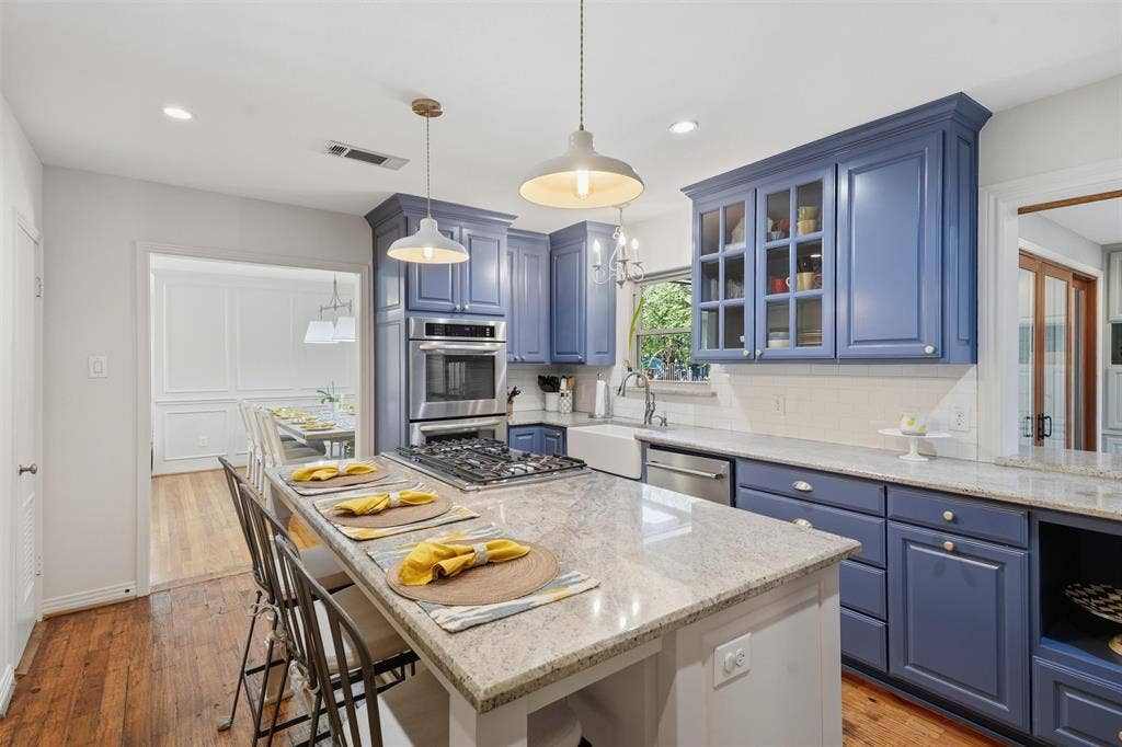 3712 Brighton Road, Fort Worth, TX 76109 Stylish chef kitchen featuring custom blue cabinetry and a center island with seating