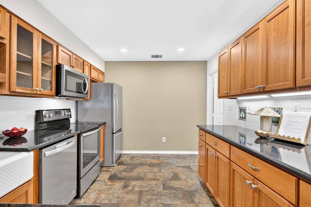 STUNNING remodeled kitchen with slate-look floors, solid wood soft close cabinetry with adjustable shelving...