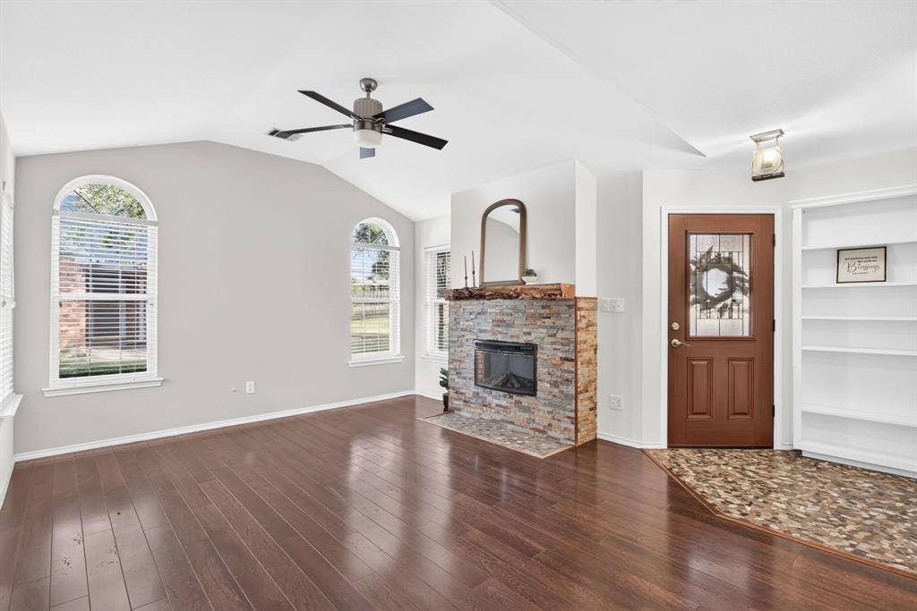 Gorgeous entryway with river rock foyer, Craftsman-style light, stacked stone fireplace and live edge mantel.