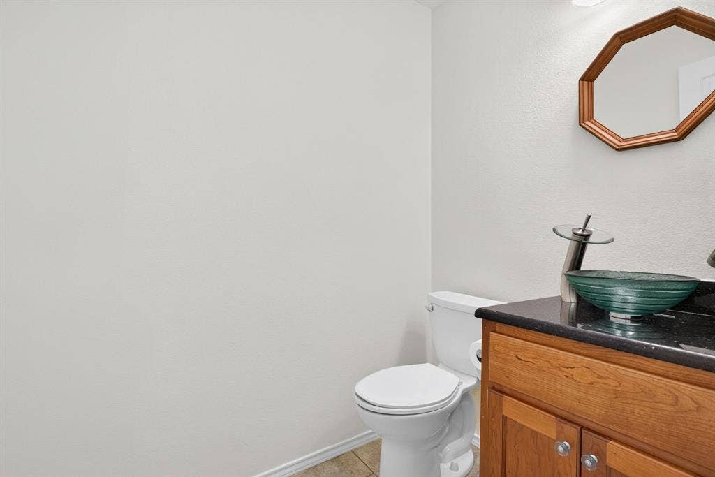 Powder bathroom with solid wood vanity, beautiful vessel sink with custom fixture and mirror.