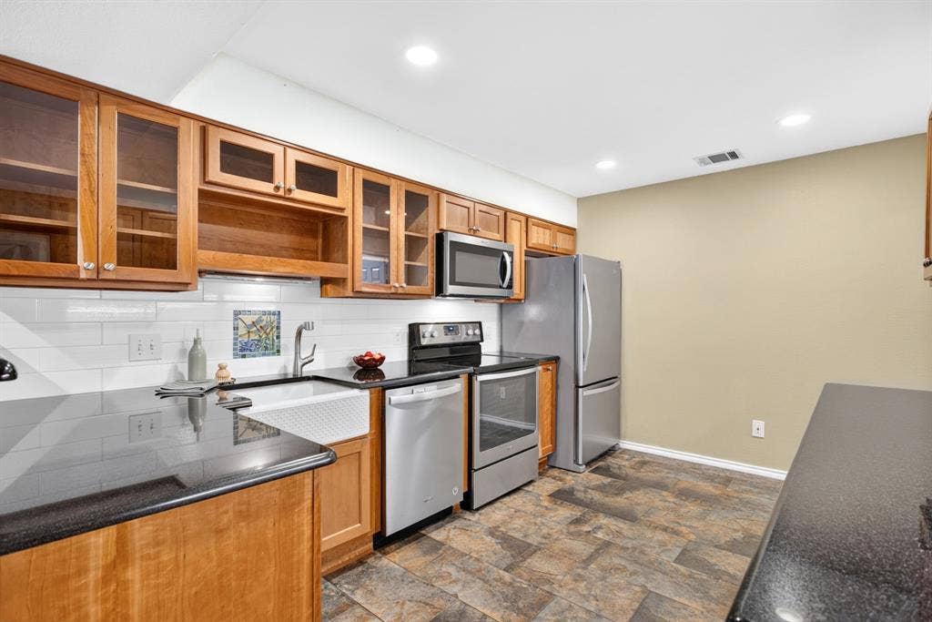 Everything in here is custom; glass front cabinets, under-cabinet lighting, arts and crafts-style mosaic backsplash vignettes.