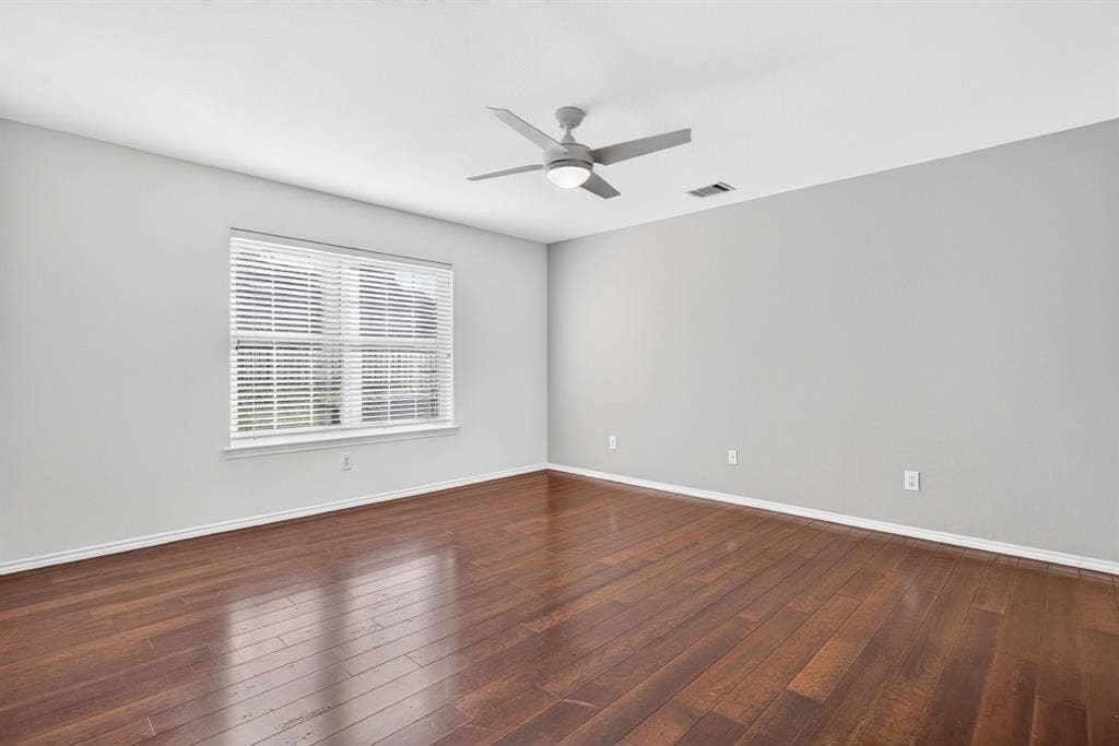 Primary suite is so spacious with hardwoods, neutral walls and new remote-controlled fan with light.