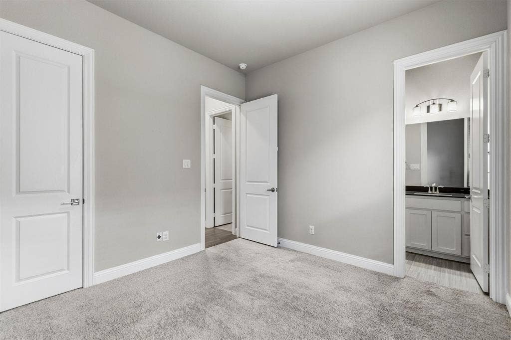 Plush carpeting and light gray wall tones create a neutral palette