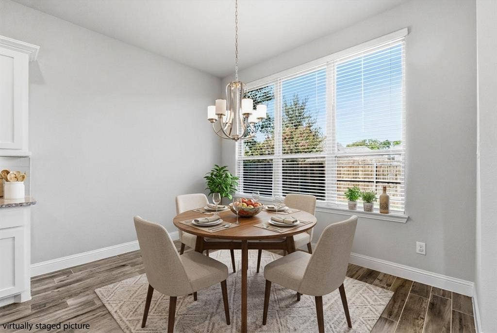 Virtually Staged - Recessed lighting, wood-finish flooring, white cabinetry, light-toned walls, and a large window