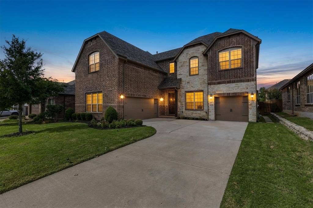 Welcome to your NEW HOME at 4128 Crowe Lane, McKinney! Beautiful brick and stone exterior, concrete driveway, three-car garage, and manicured landscaping.