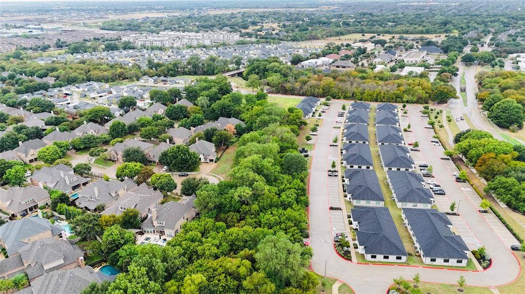 3721 S Stonebridge Drive, #704, McKinney, TX 75070 Aerial view showcasing a residential community featuring tree-lined streets, established landscaping with mature greenery, and organized residential architecture nestled within a developed neighborhood setting