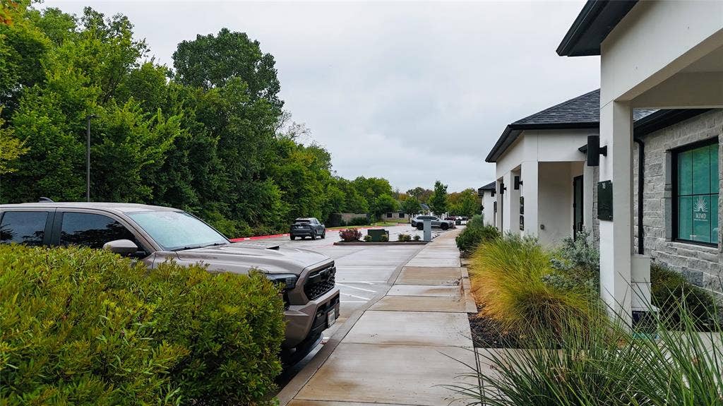 3721 S Stonebridge Drive, #704, McKinney, TX 75070 Contemporary exterior architectural design with clean lines, dark roof shingles, and stone veneer accents