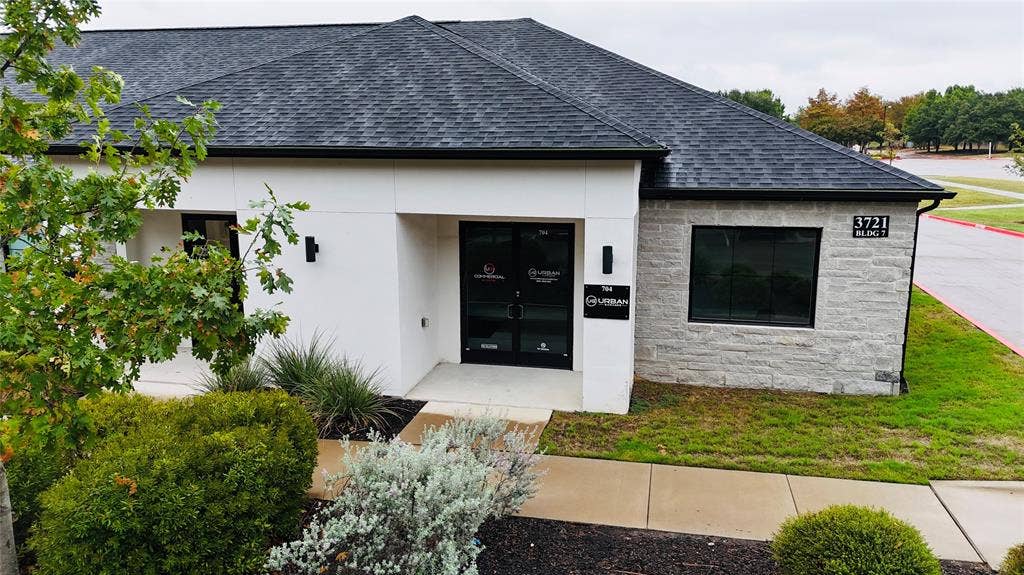 3721 S Stonebridge Drive, #704, McKinney, TX 75070 Modern exterior design with a dark shingle roof, white stucco, and stone veneer accents