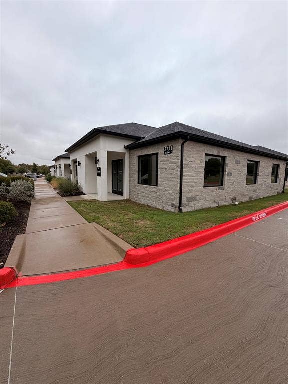 3721 S Stonebridge Drive, #704, McKinney, TX 75070 Stone veneer and stucco exterior with dark-framed windows and a dark shingled roof