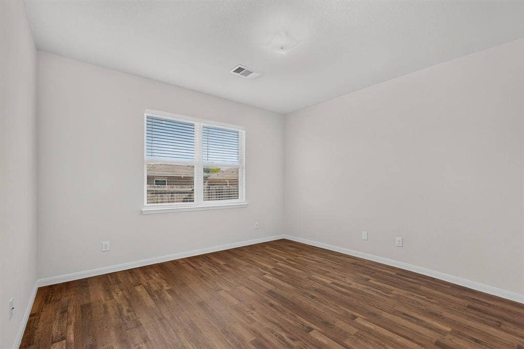 215 Magnolia Drive, Princeton, TX 75407 Wood-finish flooring with white baseboards and light-toned walls